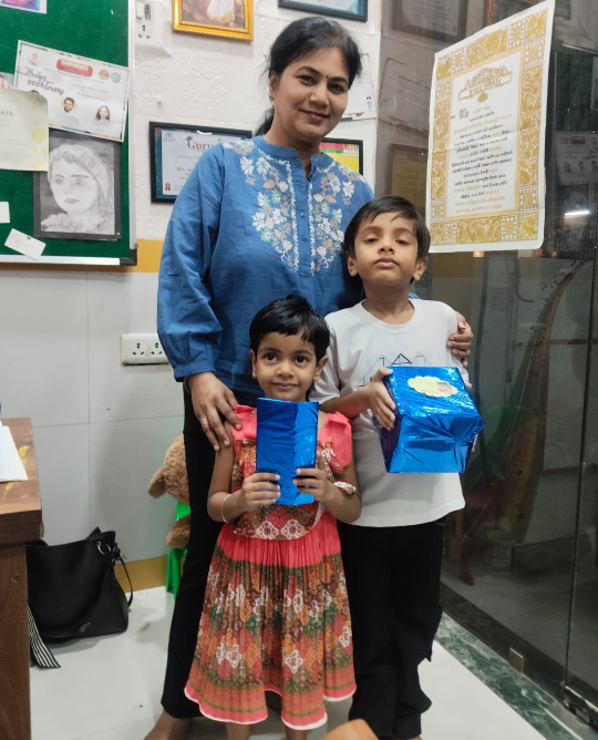 Teacher with students holding gifts at Guru Global Preschool Airoli